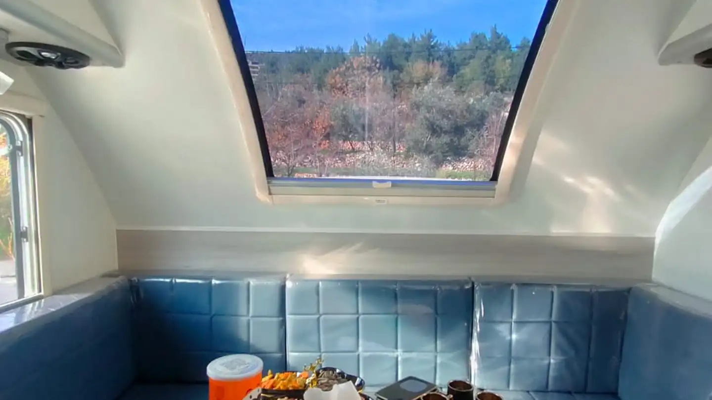Caravan lounge with a large panoramic roof window letting in light and fresh air