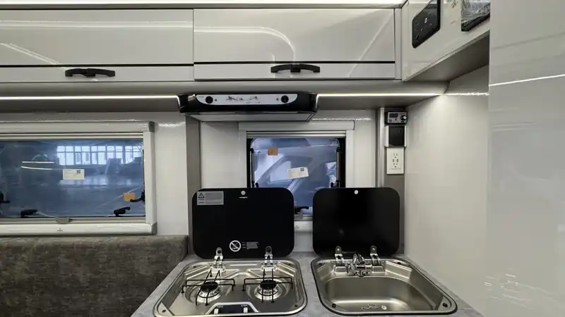 Compact kitchen in a Bijanco pickup camper with a stainless sink and two-burner stove