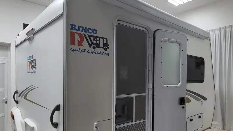 Travel trailer side entrance door with a fold-out step in a workshop showroom