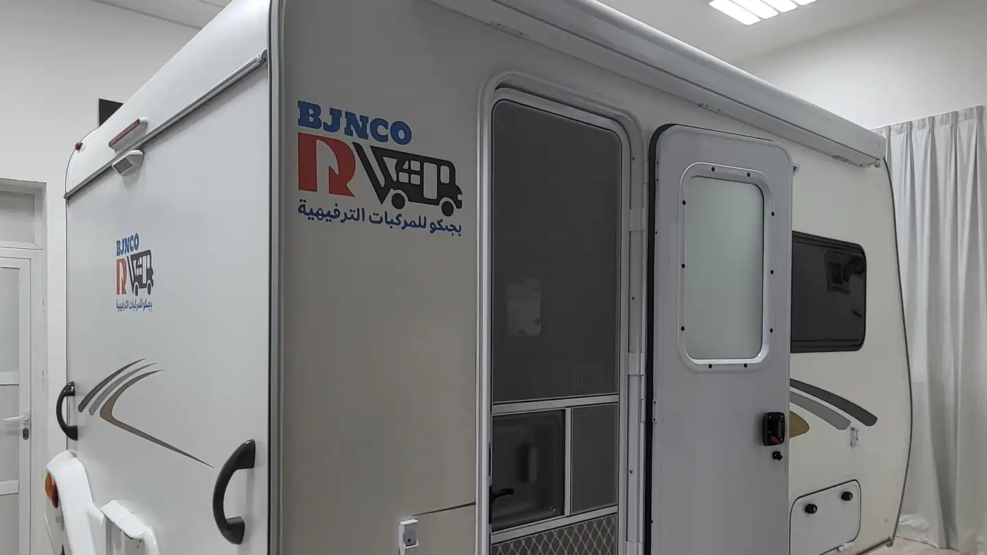 Travel trailer side entrance door with a fold-out step in a workshop showroom