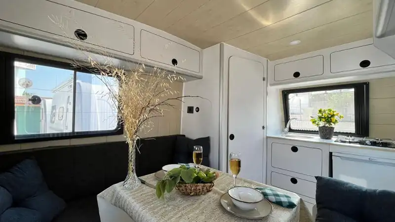 Cosy caravan dining area with cushioned benches and a set table
