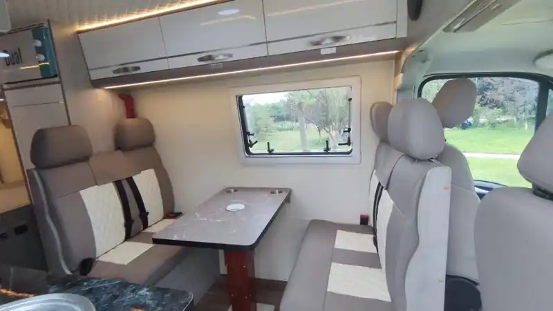 Campervan dinette with swivel seats and a table, ready for working on the road